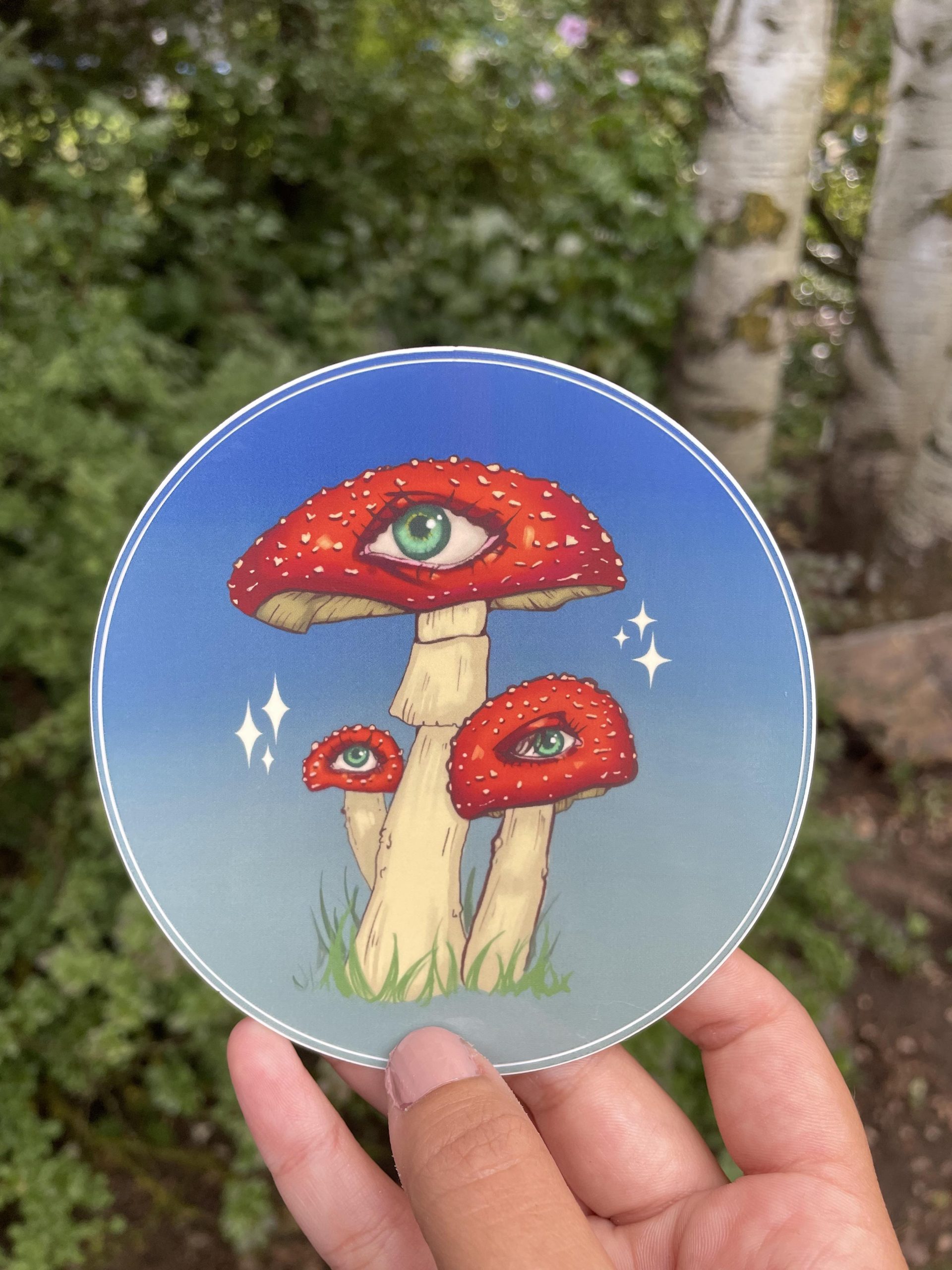 hand holding a fungeye 4 inch mushroom sticker